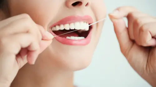 a person is flossing their teeth with a dental floss