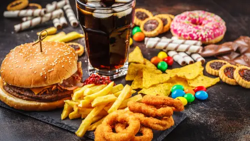 a hamburger, fries, donuts and soda on a black table