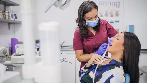 a person is getting their teeth cleaned and checked by a dentist